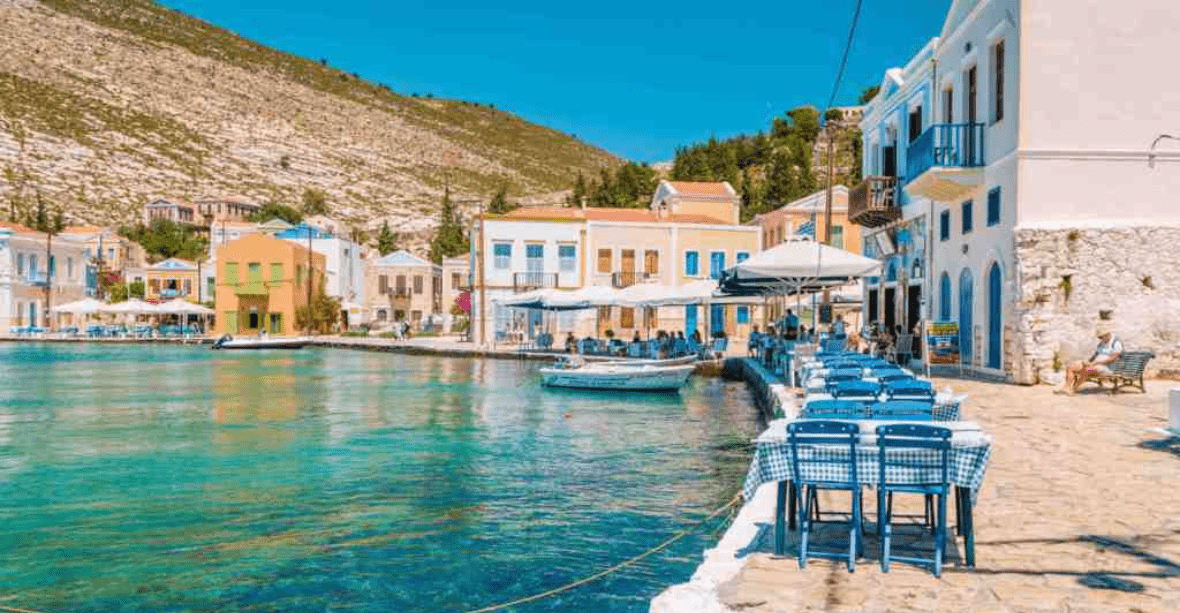 Crète bord de mer touristiques avec bars et restaurants au bord de l'eau, montagne rocheuses en arrière-plan