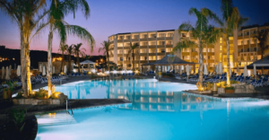 Vue de l'extérieure de l'hôtel Seabank Resort Malte avec piscines, palmiers, ainsi que l'hôtel en lui-même