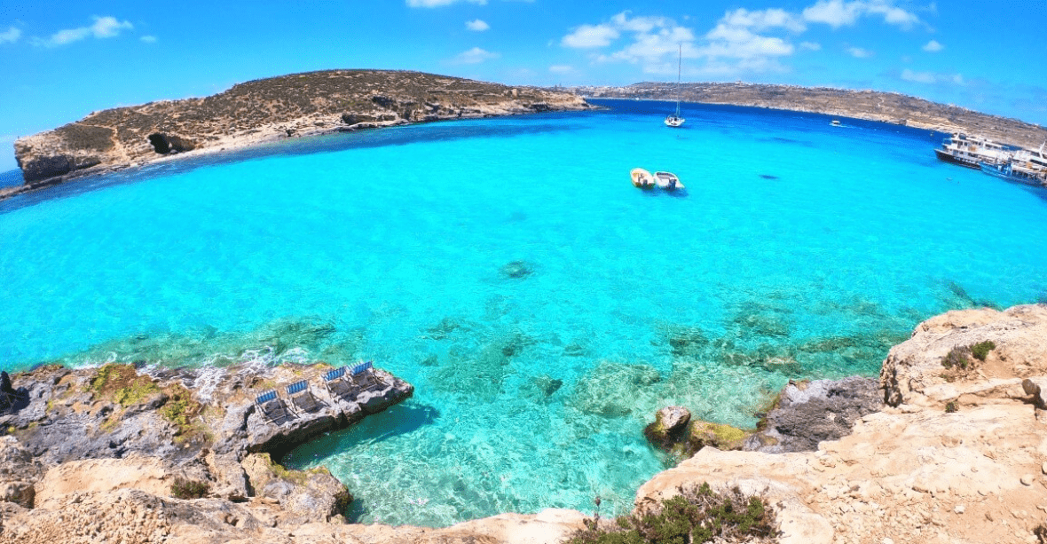 Malte - bleu lagoon mer d'un bleu turquoise très clair avec montagnes rocheuses à l'horizon