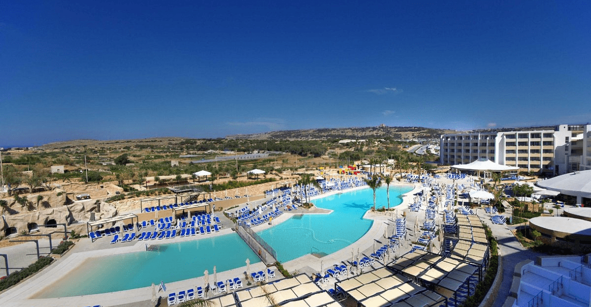 Vue de haut de l'hôtel Seabank Resort Malte avec piscine chaise longue palmiers
