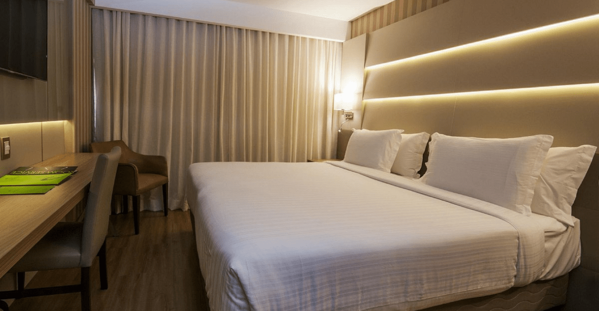 Chambre avec lit double table de nuit bureau et télé, rideau fermé hôtel Americas Copacabana - Brésil