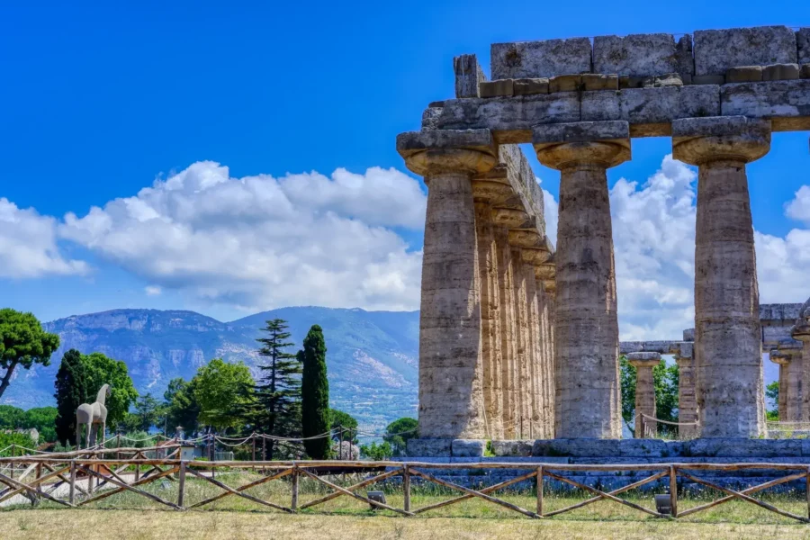 Vestiges de Paestum, un site archéologique en Italie, avec des temples grecs anciens et des ruines romaines.