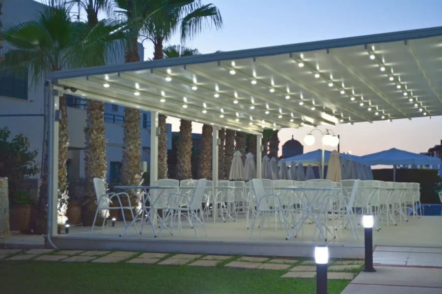 Espace lounge extérieur avec canapés et parasols à l’hôtel Angela Suites